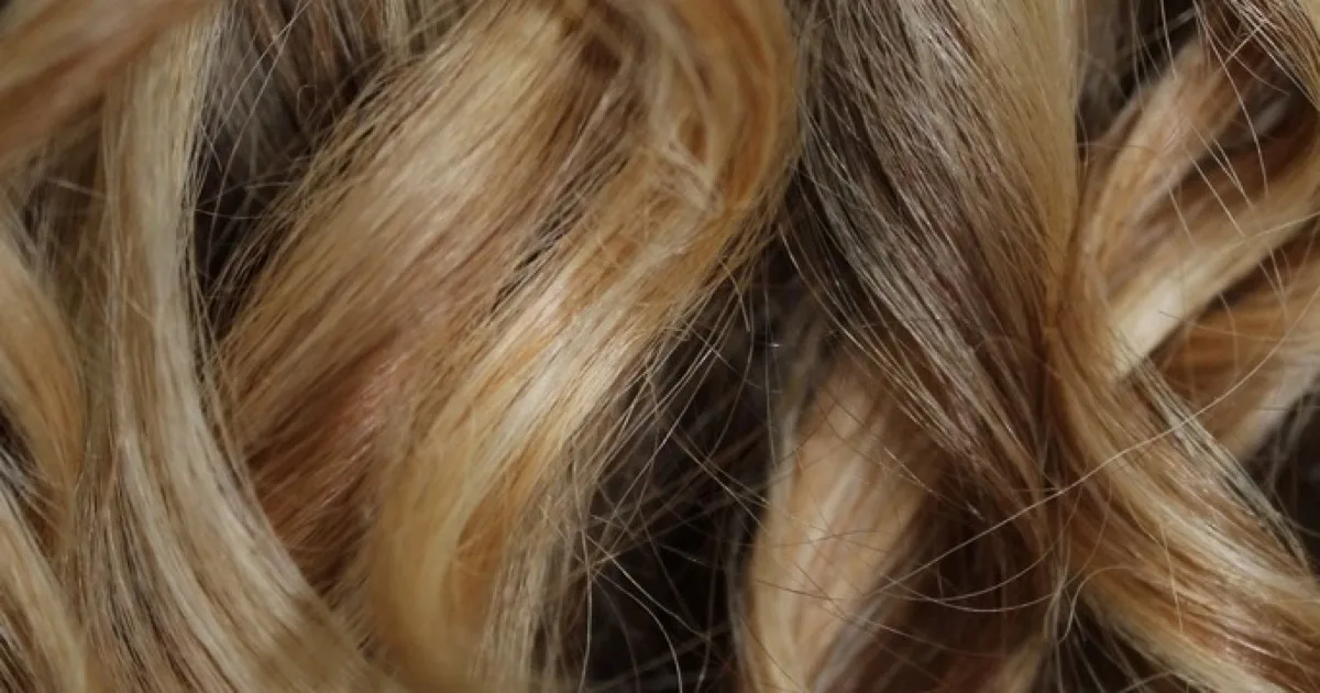 Gros plan sur des mèches de cheveux blonds bouclés