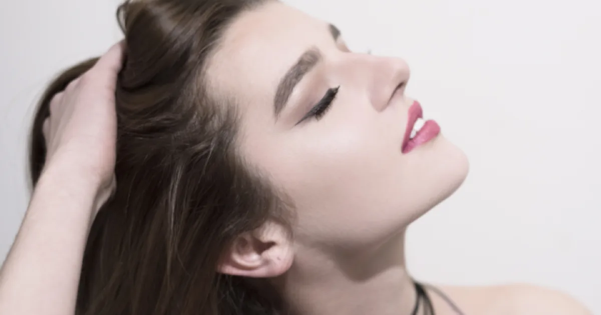 Femme de profil passant la main dans ses cheveux