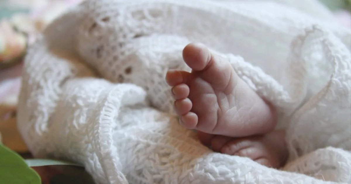 Pieds nus d'un nouveau-né enveloppé dans une couverture blanche